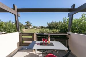 - une table sur le balcon avec des verres à vin dans l'établissement Garden Port nature, au Cap d'Agde