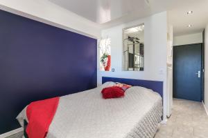 - une chambre bleue et blanche avec un lit et une couverture rouge dans l'établissement Garden Port nature, au Cap d'Agde