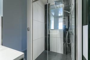 La salle de bains est pourvue d'une douche avec une porte en verre. dans l'établissement Garden Port nature, au Cap d'Agde