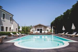 a swimming pool with chairs and a house at San Giovanni Relais in San Giovanni in Marignano