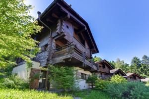 a large wooden house with a balcony and trees at Chalet Noemie in Les Houches