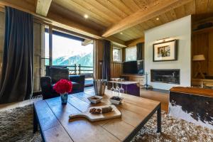a living room with a table and a large window at Chalet Noemie in Les Houches