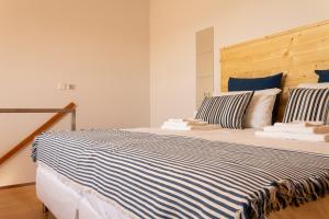 una camera da letto con un letto grande con lenzuola blu e bianche di Portus Vita Apartamento T0 Duplex a Vila Nova de Gaia Altre 27 foto