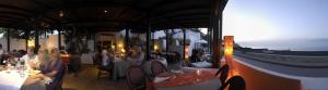 a group of people sitting at tables in a restaurant at La Sirenetta Park Hotel in Stromboli