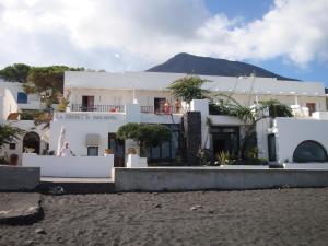 un bâtiment blanc avec une montagne en arrière-plan dans l'établissement La Sirenetta Park Hotel, à Stromboli