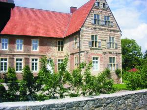 an old brick building with a red roof at Holskenbänd in Horstmar