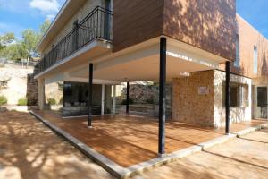 una casa con una gran terraza frente a un edificio en Hotel de Montaña La Rocha, en Quesa