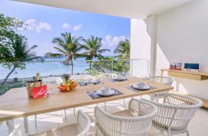 a dining room with a table and chairs with a view of the ocean at Les Estivales Beachfront Suites & Penthouses by LOV in Trou aux Biches