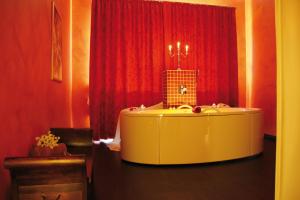 a yellow tub in a room with red curtains at Morada Strandhotel Ostseebad Kühlungsborn in Kühlungsborn