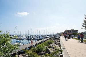 a group of people walking along a dock with boats at Morada Strandhotel Ostseebad Kühlungsborn in Kühlungsborn