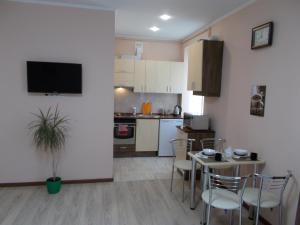 a kitchen and dining room with a table and chairs at Apartment near the Forum mall in Lviv