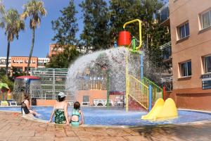 
a man and a child playing in a pool of water at Aparthotel SunClub Salou in Salou
