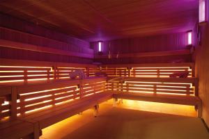 a row of benches in a room with purple lights at Morada Strandhotel Ostseebad Kühlungsborn in Kühlungsborn