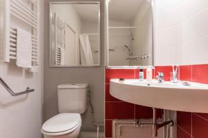 a bathroom with a white toilet and a sink at Résidence Pierre & Vacances Le Britania in La Tania