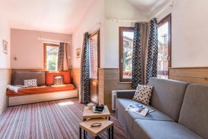 a living room with a couch and two windows at Résidence Pierre & Vacances Le Britania in La Tania