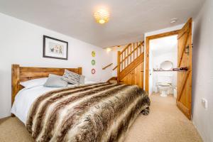 a bedroom with a large bed and a bathroom at Great Lilly Cottage in Barnstaple