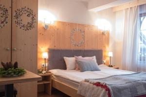 シュツァブニツァにあるウィラ ポクサのベッドルーム1室(大型ベッド1台、木製ヘッドボード付)