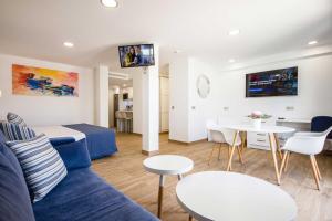 a living room with a blue couch and a table at IG Nachosol Atlantic & Yaizasol by Servatur - Adults Only in Puerto Rico de Gran Canaria