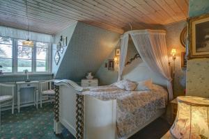 錫爾克堡的住宿－Svostrup Kro，一间卧室配有一张带天蓬的床