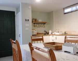 Midreshet Ben Gurion的住宿－沙漠玫瑰公寓，厨房配有桌椅和绿门。