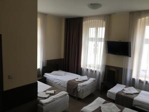 ゾンプコビツェ・シロンスキエにあるDolnośląskiのベッド3台、薄型テレビが備わるホテルルームです。