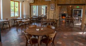 a restaurant with tables and chairs and a fireplace at Arctic River Lodge in Tärendö