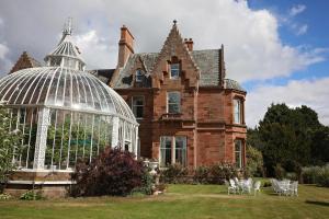 an old house with a glass greenhouse in the yard at Kingsknowes Hotel in Galashiels