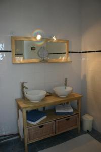 a bathroom with two sinks and a mirror at Hôtel Land'Azur in Mimizan-Plage