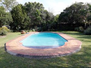 a large swimming pool in a yard with a brick at Field's Rest in Port Elizabeth