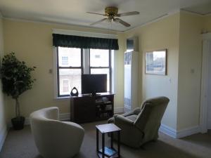 a living room with two chairs and a flat screen tv at The Polo Inn Bridgeport U.S.A. in Chicago