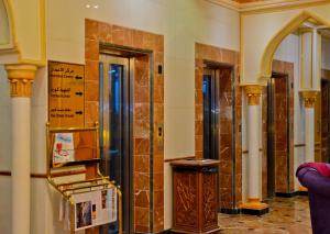 a room with a lobby with columns and a wall at Al Maha Int Hotel Oman in Muscat