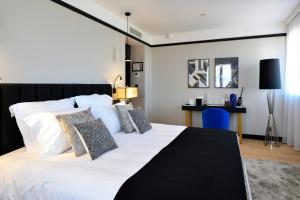 a bedroom with a large white bed with pillows at Hôtel Restaurant le Touring - Teritoria in Saint-Raphaël