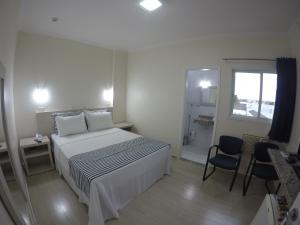 a white bedroom with a bed and a window at Dumont Park Hotel in Sao Jose do Rio Preto