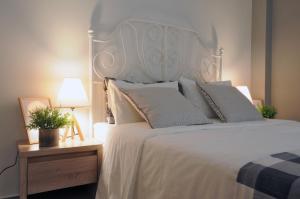 a bedroom with a large white bed and a table with a lamp at F & B Collection - close to Aristotelous sQ. in Thessaloniki
