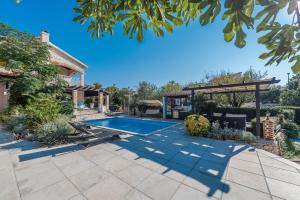 um quintal com uma piscina e uma pérgola em Poolside Stone Residences - Marina Bok em Novalja