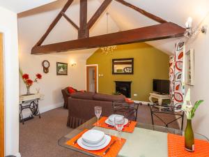 a living room with a couch and a table at Bodafon Hall Cottages in Llandudno
