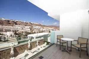 a balcony with a table and chairs and a view at IG Nachosol Atlantic & Yaizasol by Servatur - Adults Only in Puerto Rico de Gran Canaria