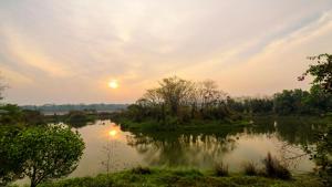 Blick auf einen Fluss bei Sonnenuntergang in der Unterkunft The Riverwood Forest Retreat Dooars - fully vaccinated staff in Neorā Nadī