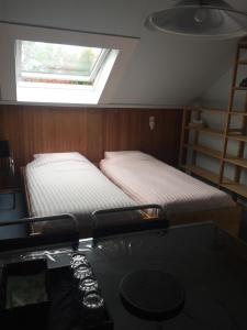 two beds in a room with a desk and a window at Cozy room in residential Alkmaar - Free parking in Alkmaar