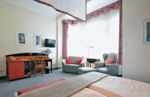 a hotel room with a bed and a desk and chairs at Hotel Jugendstil in Hameln