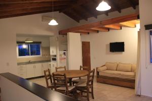 cocina y sala de estar con mesa y sofá en Cabañas del Rey en Villa Carlos Paz