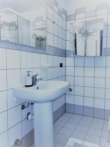 Baño blanco con lavabo y espejos en Viale Monza Apartment, en Milán