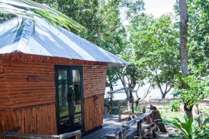 a wooden cabin with a glass door and a bench at Ban_na in Ko Chang
