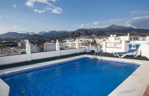 a swimming pool on top of a building with a view at Hotel Bajamar Centro in Nerja
