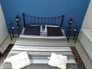 a large bed with blue walls and two night stands at Seafarer's Suite in Galaxidi