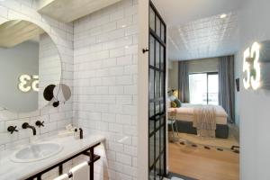 a bathroom with a sink and a bedroom at COCO-MAT Athens Jumelle in Athens +42 photos