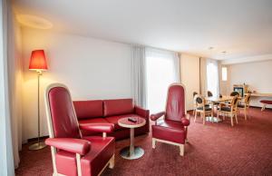 a living room filled with furniture and a red couch at ARCOTEL Rubin - im Szeneviertel St Georg in Hamburg