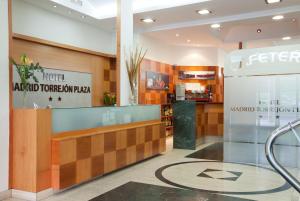 Hotel Madrid Torrejon Plaza في توريخون ذي أرذوث: لوبي فندق مع اوريا