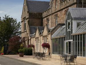 a building with tables and chairs in front of it at Macdonald Inchyra Hotel & Spa in Falkirk