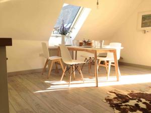 mesa y sillas en una habitación con ventana en The Loft, en Pilton